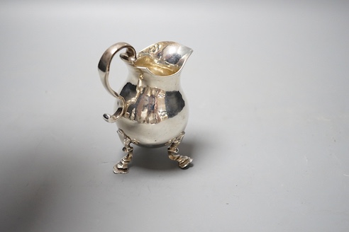 A George V silver cream jug, on tripod feet, William Comyns & Sons Ltd, London, 1928, 10.2cm, 5oz.